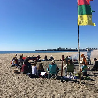 Reunión de práctica en la playa con banderas de colores